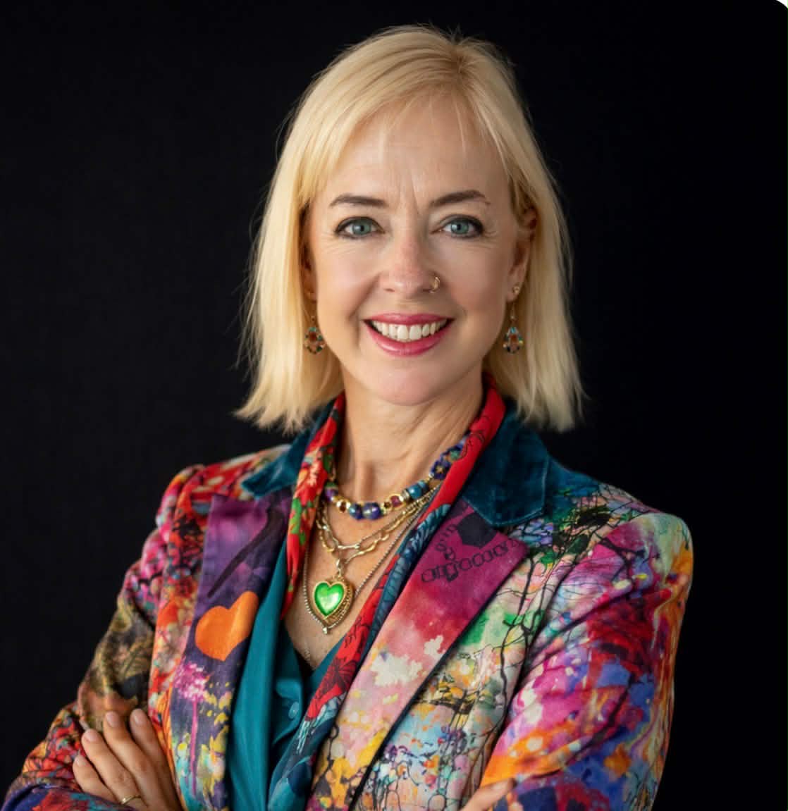 Kimberly Brayman wearing a colorful jacket with a black background